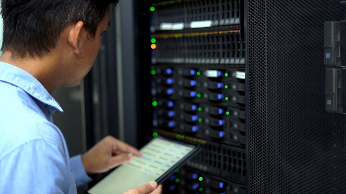 IT technician monitoring and maintaining systems in a data centre, representing ongoing technical support and maintenance