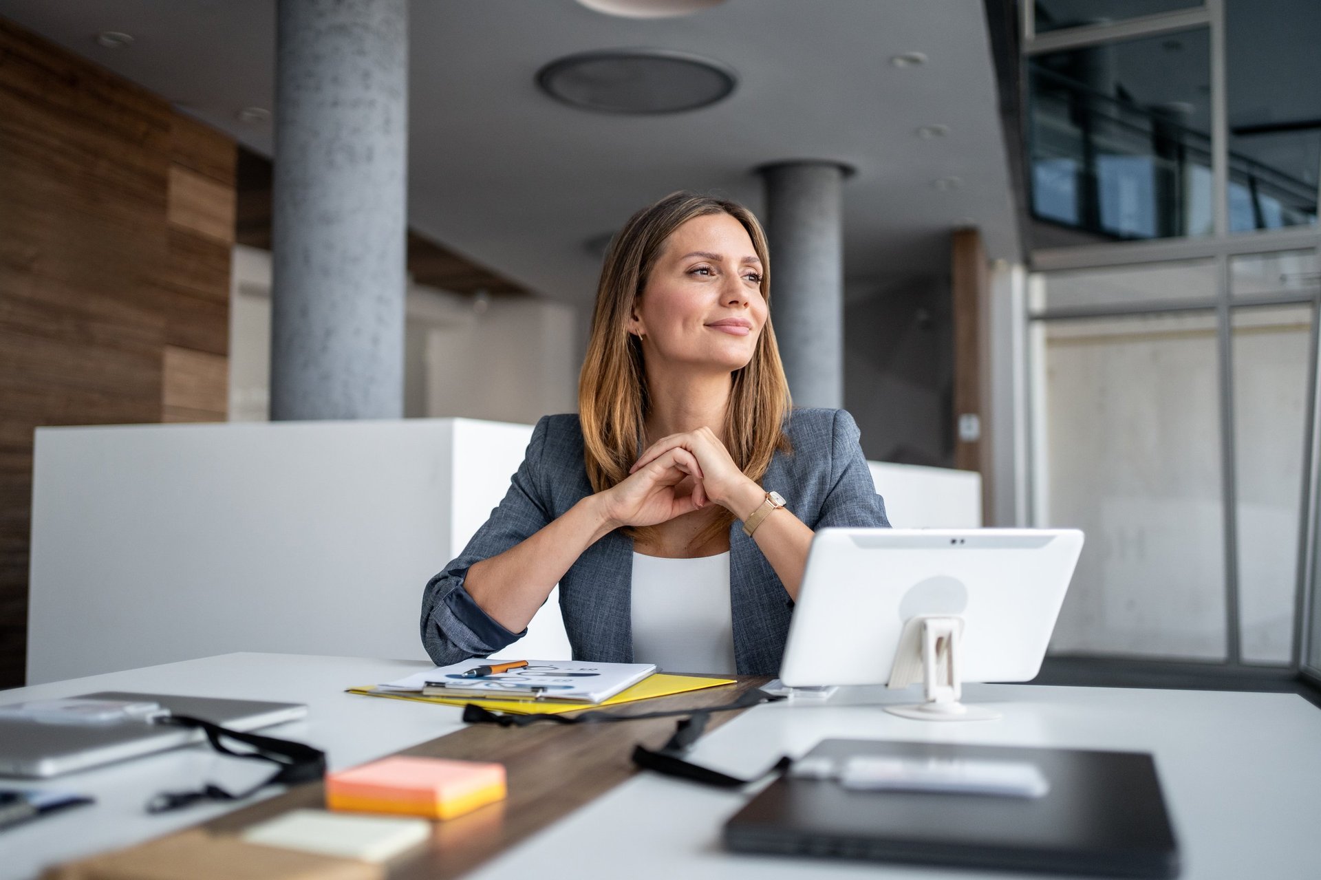 Businesswoman at a modern office desk contemplating workforce planning and future business strategy