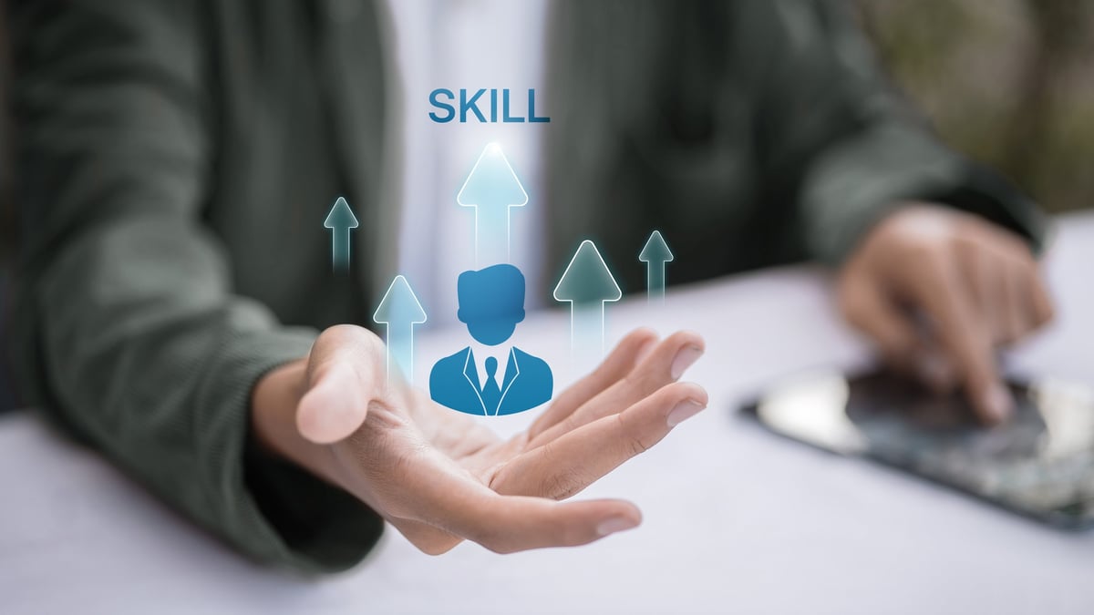 Hand presenting skill icon with upward arrows near tablet; employee training, upskilling and reskilling for career growth; HR development, talent management and performance improvement concept
