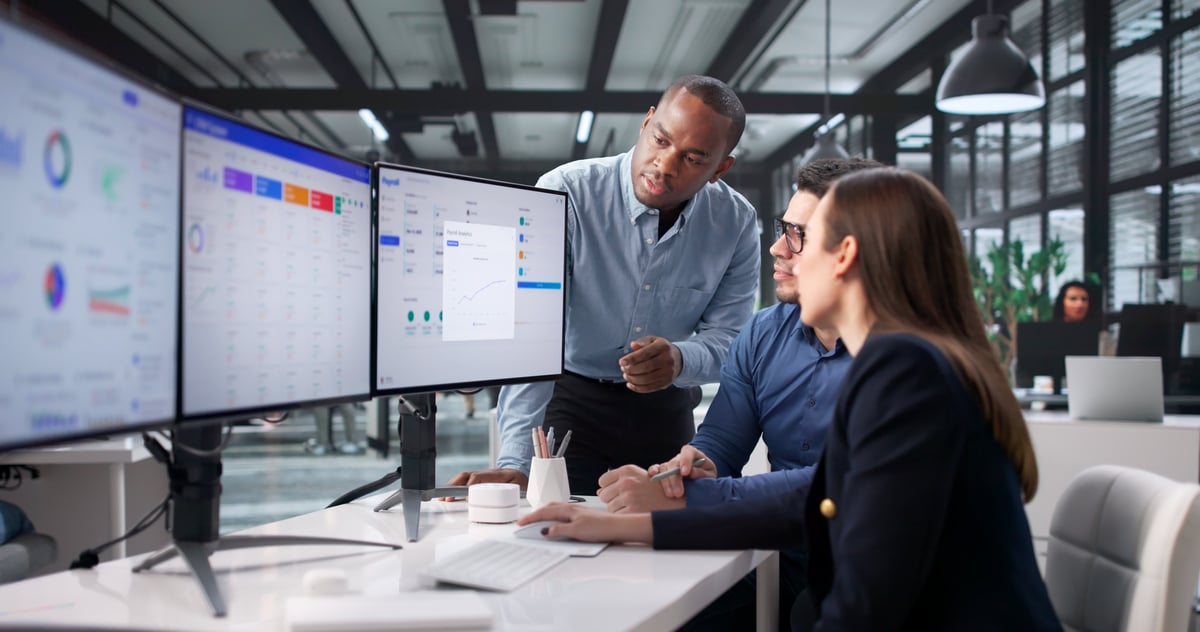 A diverse team collaborating on data and operations in a modern office environment, representing operational digital transformation