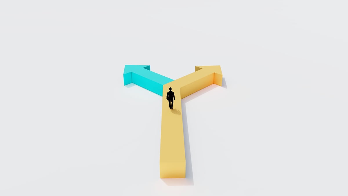 Businessman facing two opposite arrow paths, representing choosing between common misconceptions and reality