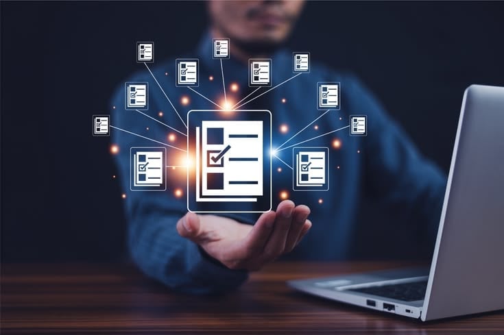 Person holding a digital tablet displaying a checklist with connected document icons radiating around it, representing file management and organization